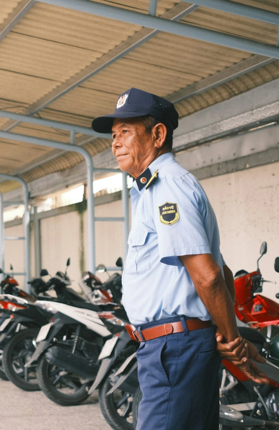 man in white long sleeve shirt and black hat standing beside motorcycle