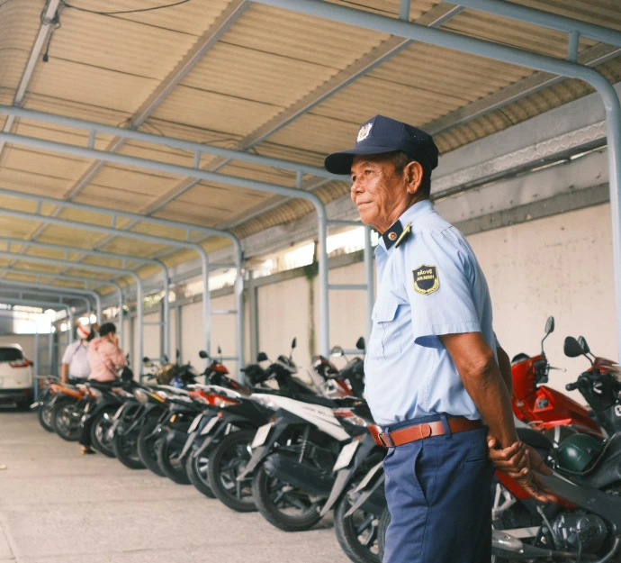 man in white long sleeve shirt and black hat standing beside motorcycle