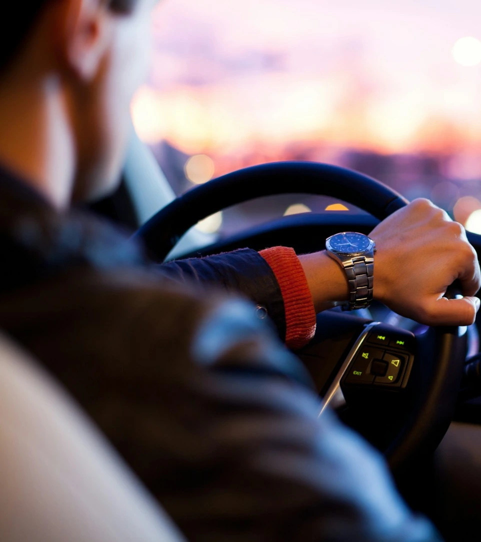 man driving a car wearing wrist watch