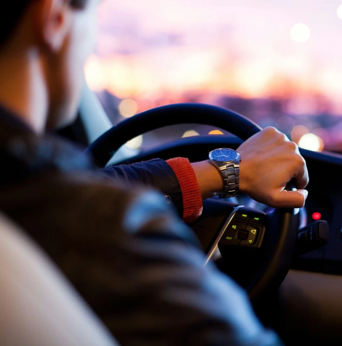 man driving a car wearing wrist watch